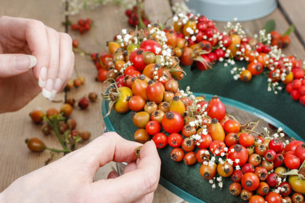 Florist at work: steps of making door wreath